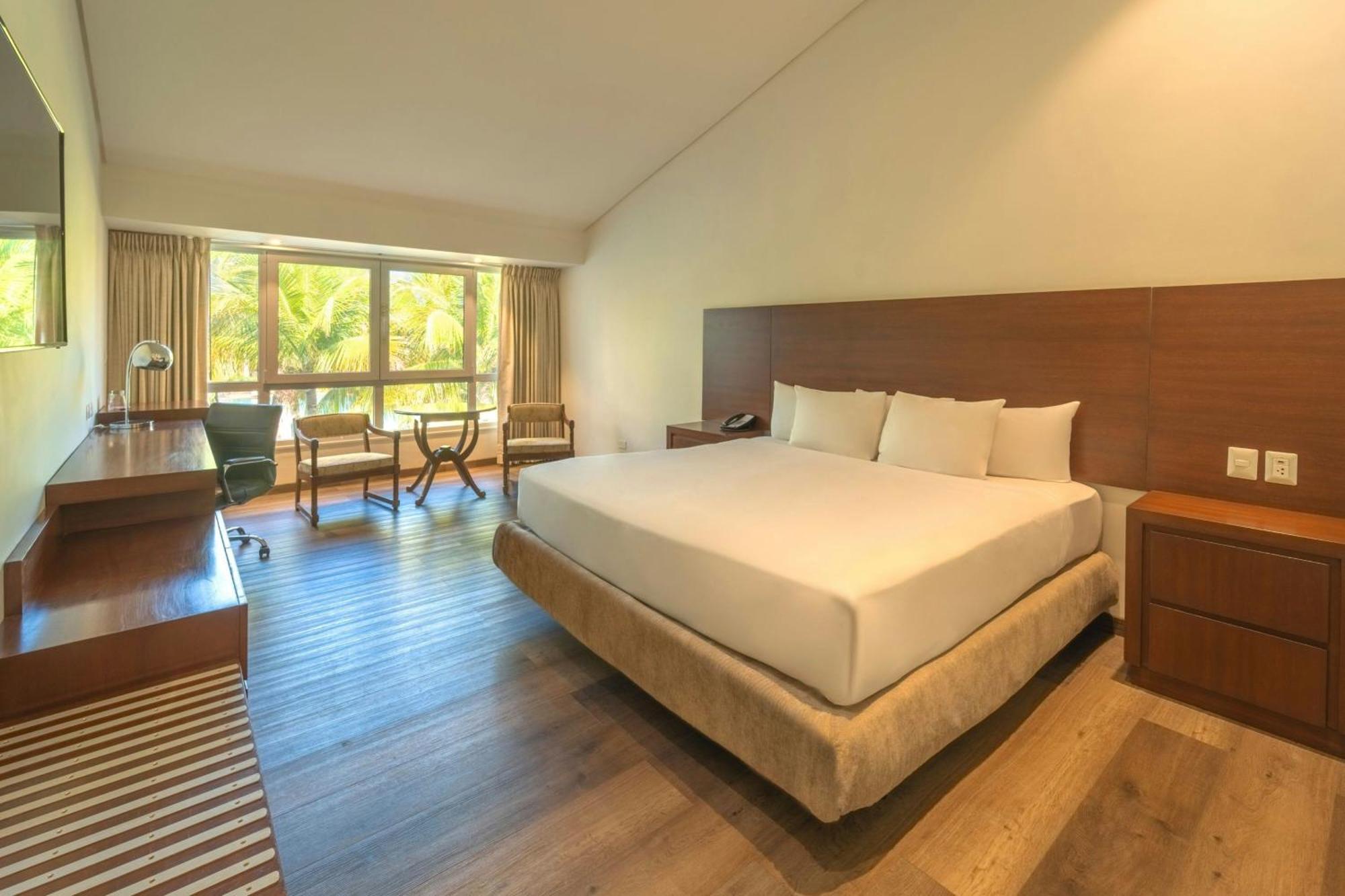 Habitación con cama extragrande y vistas a la piscina