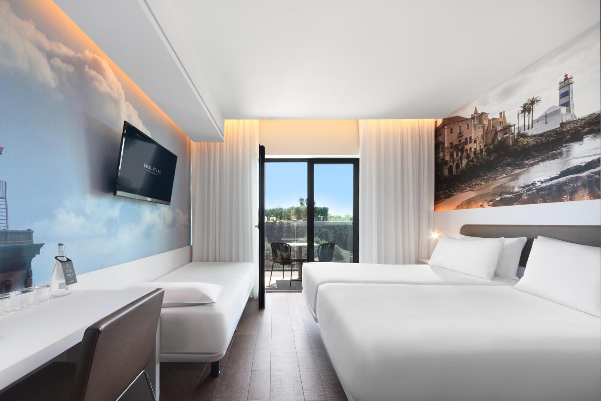 Dreibettzimmer mit Balkon und Stadtblick