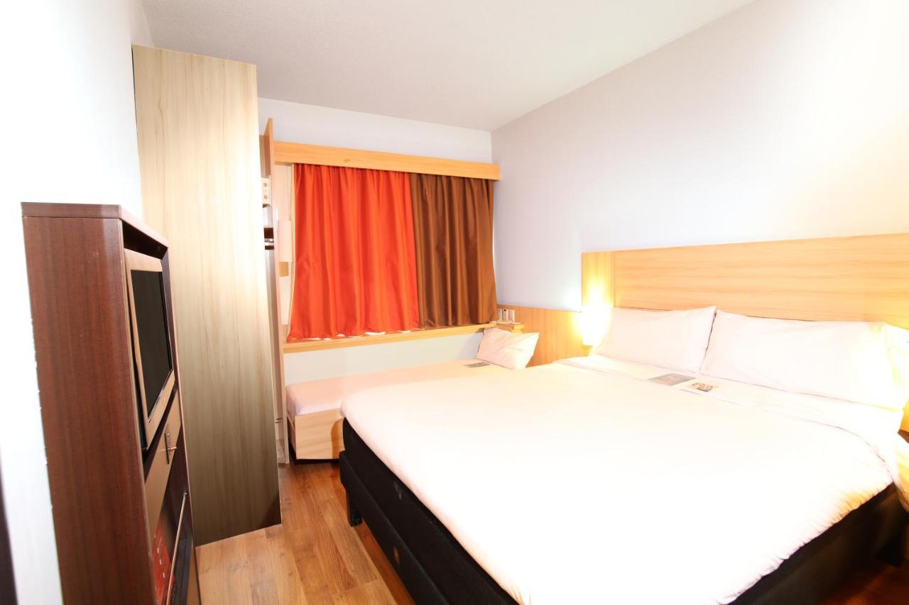 Habitación con cama grande y cama supletoria